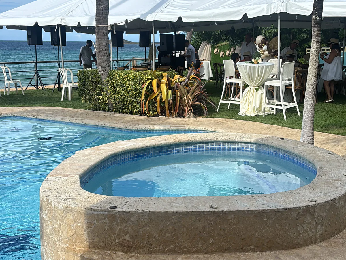 Carpa blanca para una celebración junto a una piscina con vista al mar